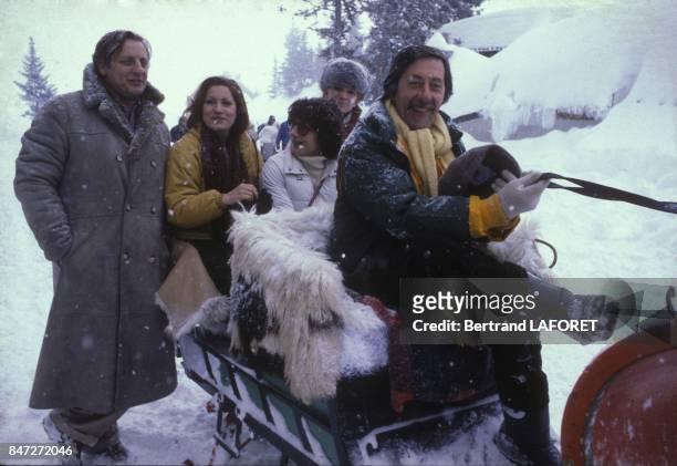 Actor Jean Rochefort leading a sled at Avoriaz Film Festival with Bruno Cremer and Andrea Ferreol on left in January 1981 in Avoriaz, France.
