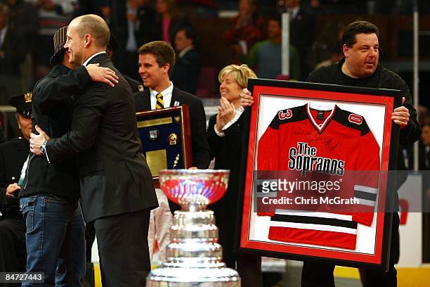 Steve Schirripa of The Sopranos presents former New York Rangers player Adam Graves with a framed jersey during a ceremony retiring his jersey prior...