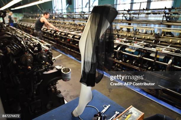 Worker on a machine manufactures silk stockings in the society of Arsoie on September 7, 2017 in Sumène in the southern France. / AFP PHOTO / Pascal...