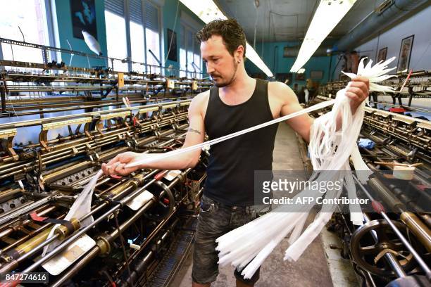 Employee works on a weaving loom in the factory of silk stockings and underwear manufacture company Arsoie Cervin on September 7, 2017 in Sumene,...