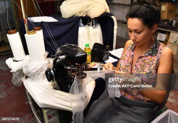 Employee works with a knitting machine to assemble stockings in the factory of silk stockings and underwear manufacture company Arsoie Cervin on...