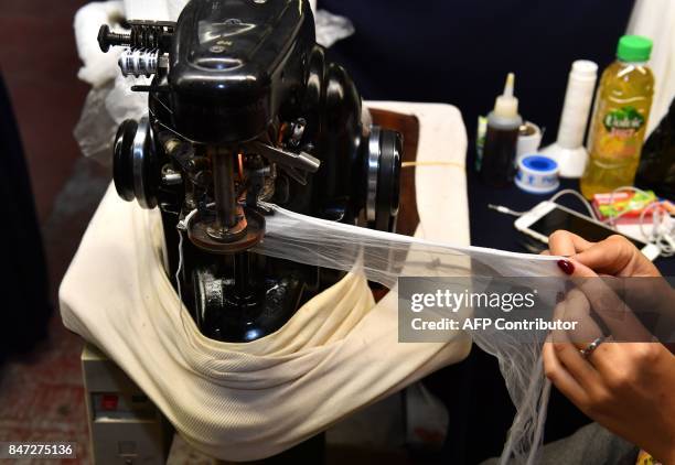 Employee works with a knitting machine to assemble stockings in the factory of silk stockings and underwear manufacture company Arsoie Cervin on...