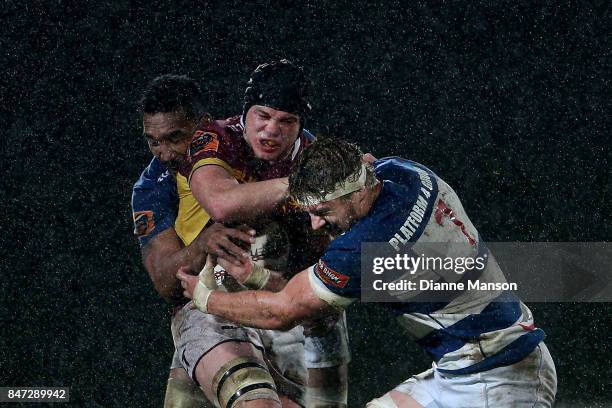 Phil Halder of Southland is tackled by Jerome Kaino and Blake Gibson of Auckland during the round five Mitre 10 match between Southland and Auckland...