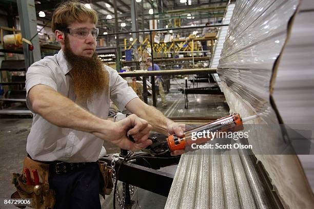 Worker at Jayco, Inc., the country's third largest maker of recreational vehicles, prepares to put siding on a Jay Flight travel trailer February 10,...