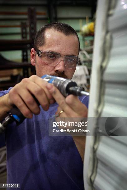 Worker at Jayco, Inc., the country's third largest maker of recreational vehicles, helps to construct a Jay Flight travel trailer February 10, 2009...