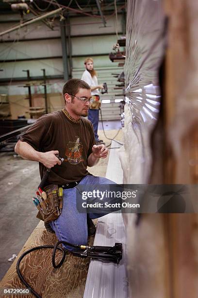 Workers at Jayco, Inc., the country's third largest maker of recreational vehicles, put siding on a Jay Flight travel trailer February 10, 2009 in...