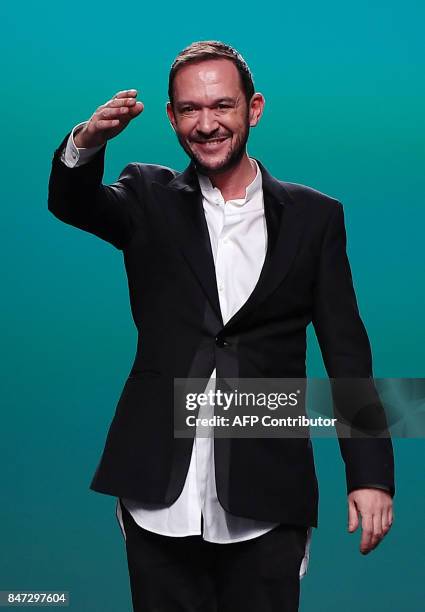 Spanish designer Ulises Merida waves from the catwalk after presenting his Spring/Summer 2018 collection during the Madrid Fashion Week in Madrid on...