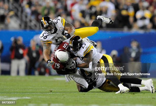 Linebacker LaMarr Woodley and safety Ryan Clark of the Pittsburgh Steelers tackle wide receiver Steve Breaston of the Arizona Cardinals during Super...