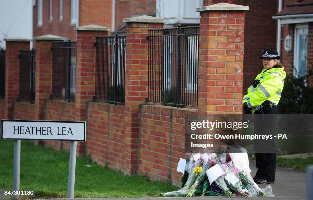 Police officer stands by floral tributes outside the home of Pc David Rathband in Blyth, Northumberland, after he was found dead at the house in a...