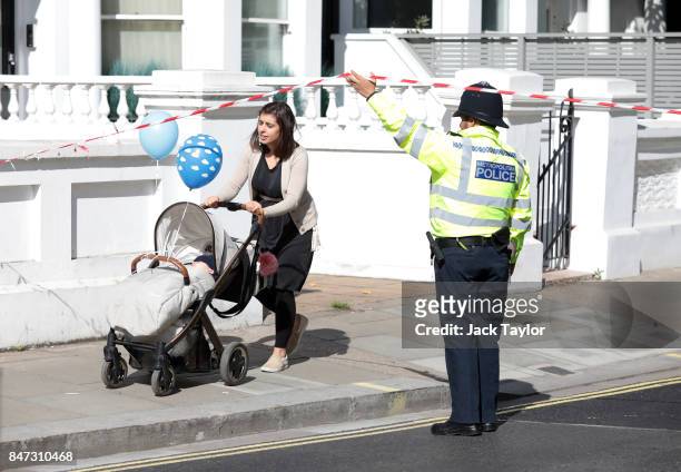 Woman with her young child leaves the police cordon at Parsons Green Underground Station on September 15, 2017 in London, England. Several people...