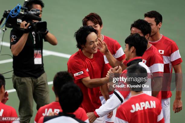 Go Soeda of Japan celebrates with his team mates after winning his singles match against Thiago Monteiro of Brazil during day one of the Davis Cup...