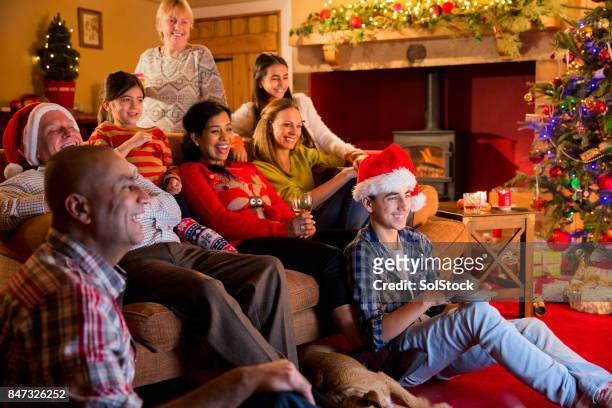 family watching christmas television - family tv stock pictures, royalty-free photos & images