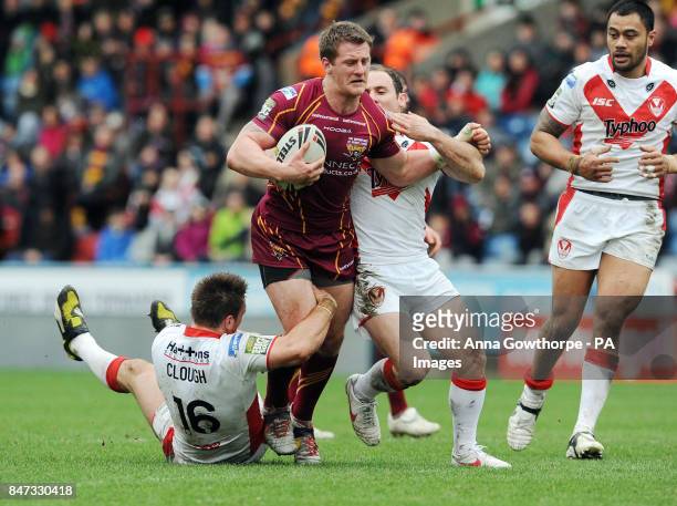 Huddersfield Giants' Larne Patrick is tackled by St Helens' Paul Clough and Lance Hohaia during the Stobart Super League match at the Galpharm...