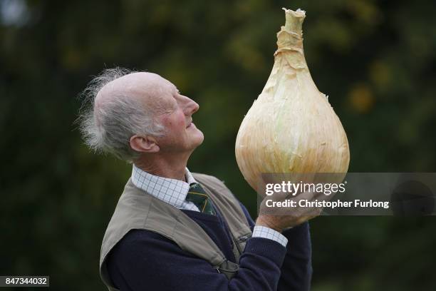 Giant vegetable grower Peter Glazebrook from Newark poses with his giant award winning onion that weighed in at 6.65kg at the Harrogate Autumn Flower...