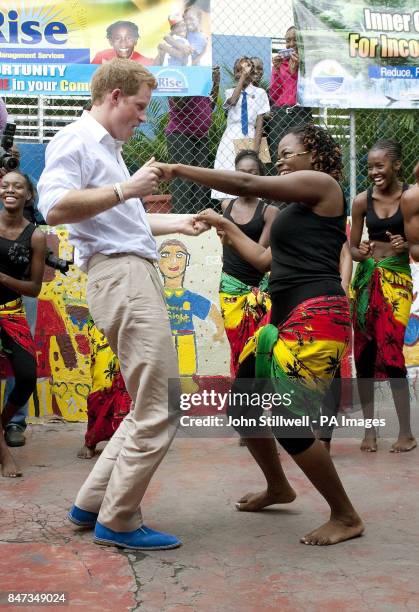 Prince Harry dances with Chantol Dorner during a visit to the Rise Life charity project , in Jamaica, as part of a Diamond Jubilee tour where he is a...