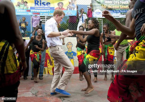 Prince Harry dances with Chantol Dorner during a visit to the Rise Life charity project , in Jamaica, as part of a Diamond Jubilee tour where he is a...