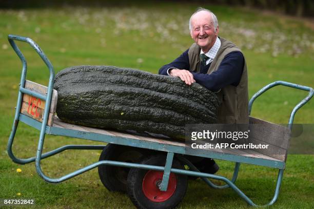 Peter Glazebrook poses for a photograph with his 66.8 kg marrow which won its class in the giant vegetable competition on the first day of the...