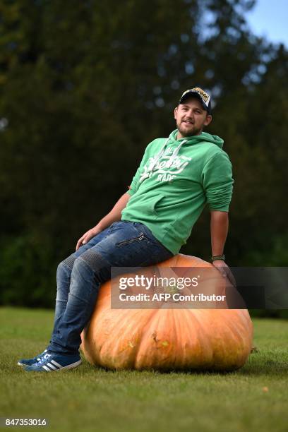 Richard Mann poses for a photograph with his 310.7 kg pumpkin which won its class in the giant vegetable competition on the first day of the...