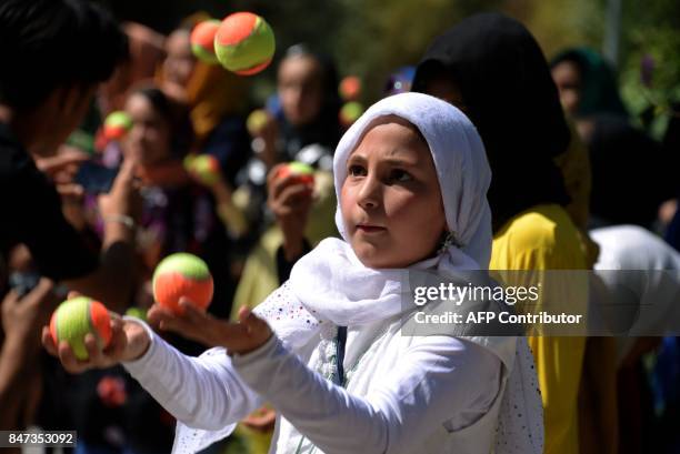 In this photograph taken on September 14, 2017 Afghan children juggle with balls during an activity organized by the Mobile Mini Circus for Children...