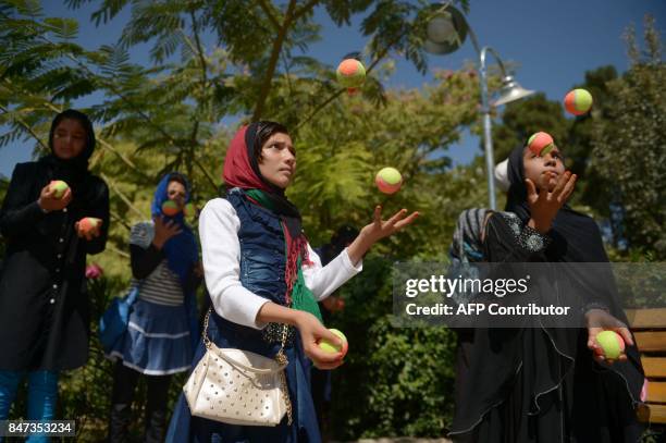 In this photograph taken on September 14, 2017 Afghan children juggle with balls during an activity organized by the Mobile Mini Circus for Children...