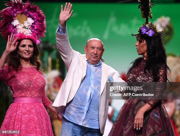 Spanish designer Francis Montesinos waves flanked by singers Antonia Salazar and her sister Encarna Salazar, members of the musical duo 'Azucar...