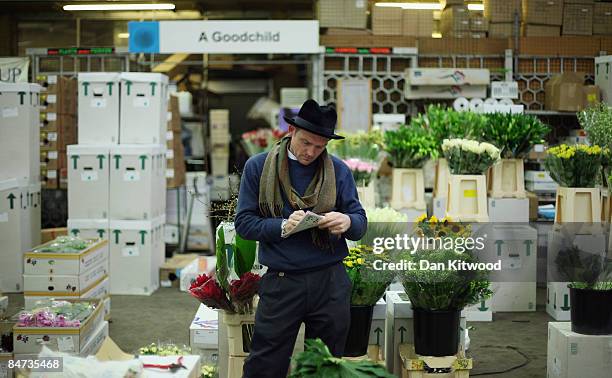 Market vendor works at his stall in New Covent Garden Flower Market on February 11, 2009 in London, England. New Covent Garden Flower Market is...