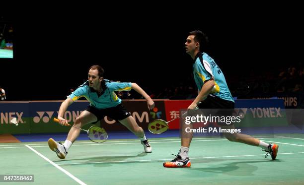 Andrew Ellis returns watched by his playing partner Chris Adcock during their match during the Yonex All England Badminton Championships at the...