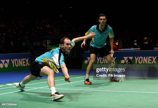 England's Andrew Ellis returns watched by Chris Adcock during the Yonex All England Badminton Championships at the National Indoor Arena in...