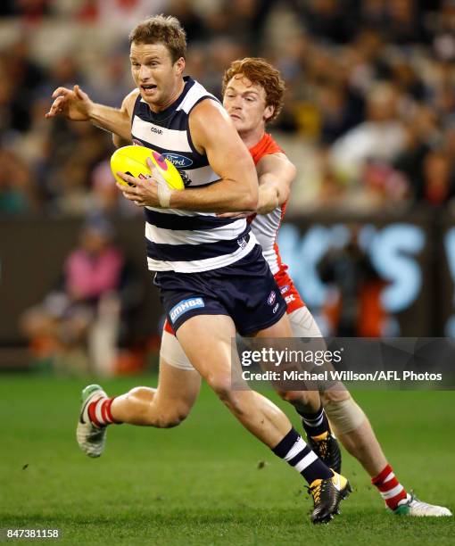 Lachie Henderson of the Cats is tackled by Gary Rohan of the Swans during the 2017 AFL Second Semi Final match between the Geelong Cats and the...