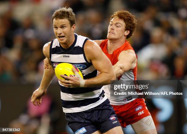 Lachie Henderson of the Cats is tackled by Gary Rohan of the Swans during the 2017 AFL Second Semi Final match between the Geelong Cats and the...