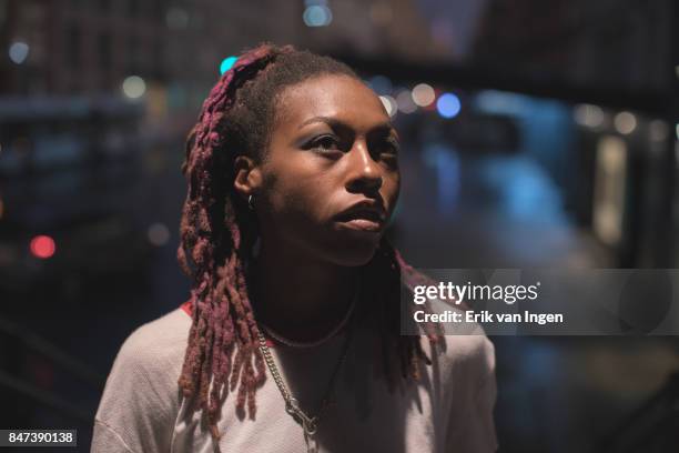a streetlight portrait of a young, african american woman in new york. - purple blouse stock pictures, royalty-free photos & images