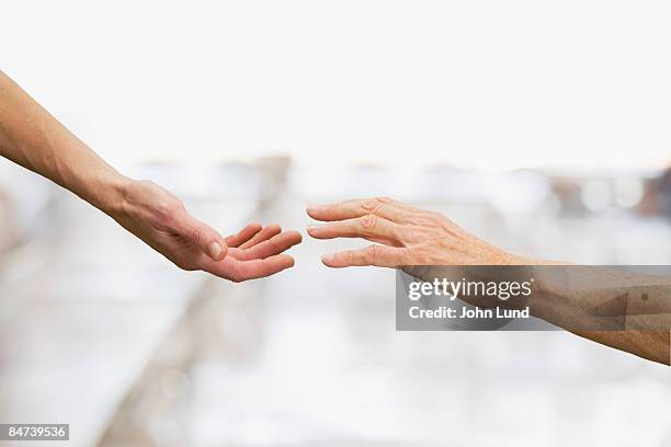 two hands reaching - uomo donna per mano foto e immagini stock