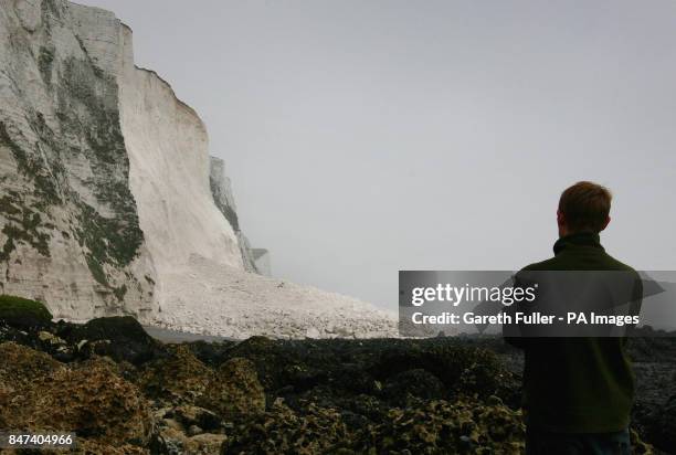 Man views the pile of rocks left on the beach between Langdon Cliffs and South Foreland Lighthouse, after a large section of the famous White Cliffs...