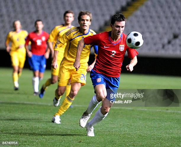 Serbia's Antonio Rukavina chases down the ball followed by Marko Devic of Ukraine during their FIFA international friendly football match in the...