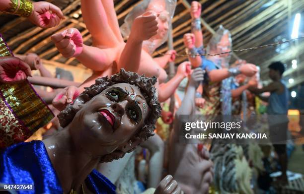 An Indian artist works on a statue of the Hindu goddess Durga ahead of the forthcoming Navratri Durga festival at a workshop in Allahabad on...