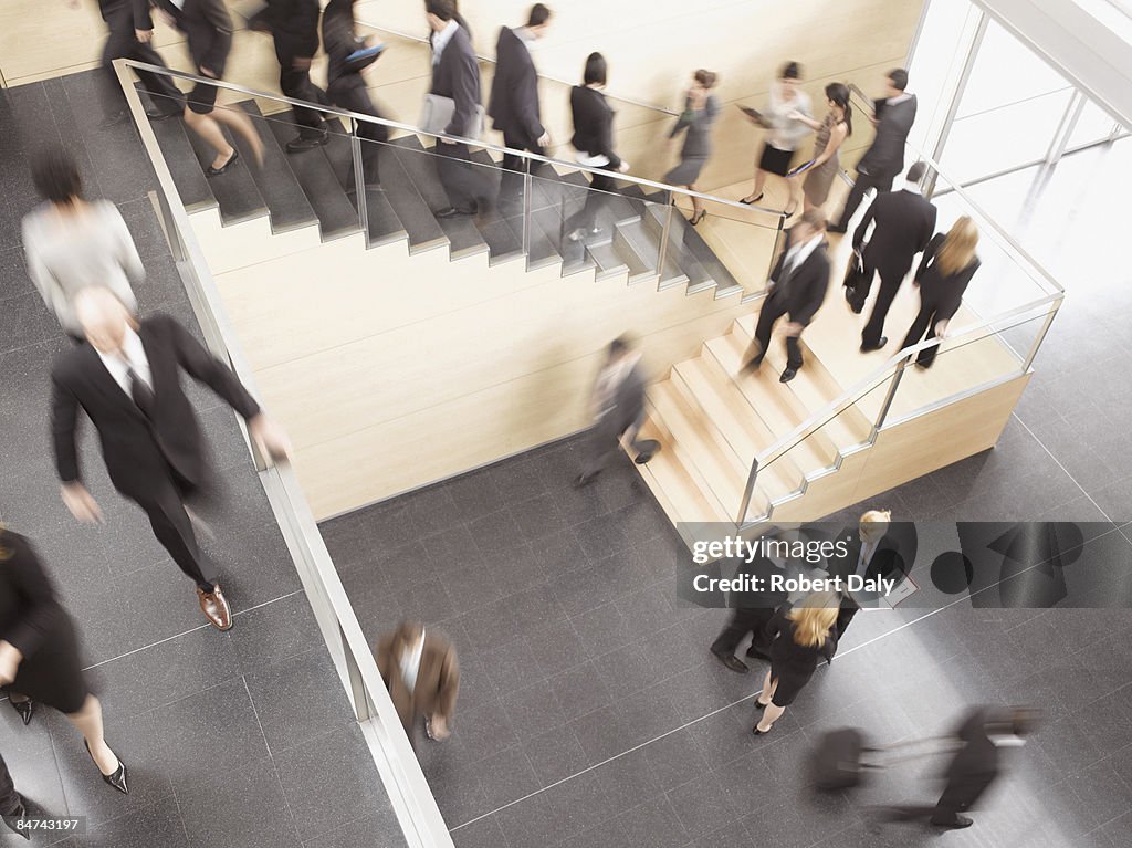 Businesspeople walking in busy office building