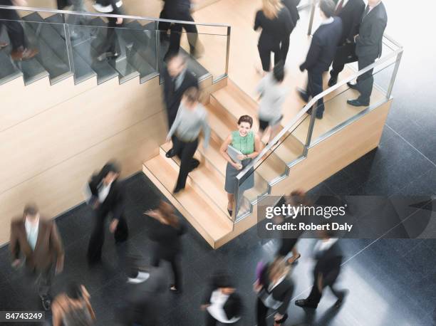 businessman leaning on busy office staircase - calm down stock pictures, royalty-free photos & images