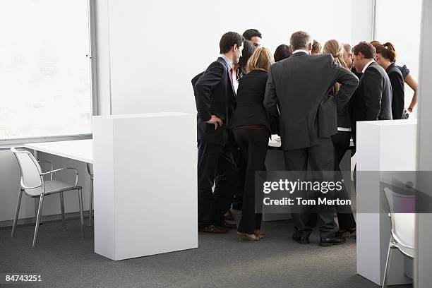 businesspeople gathering in corner of office - bustling office stockfoto's en -beelden