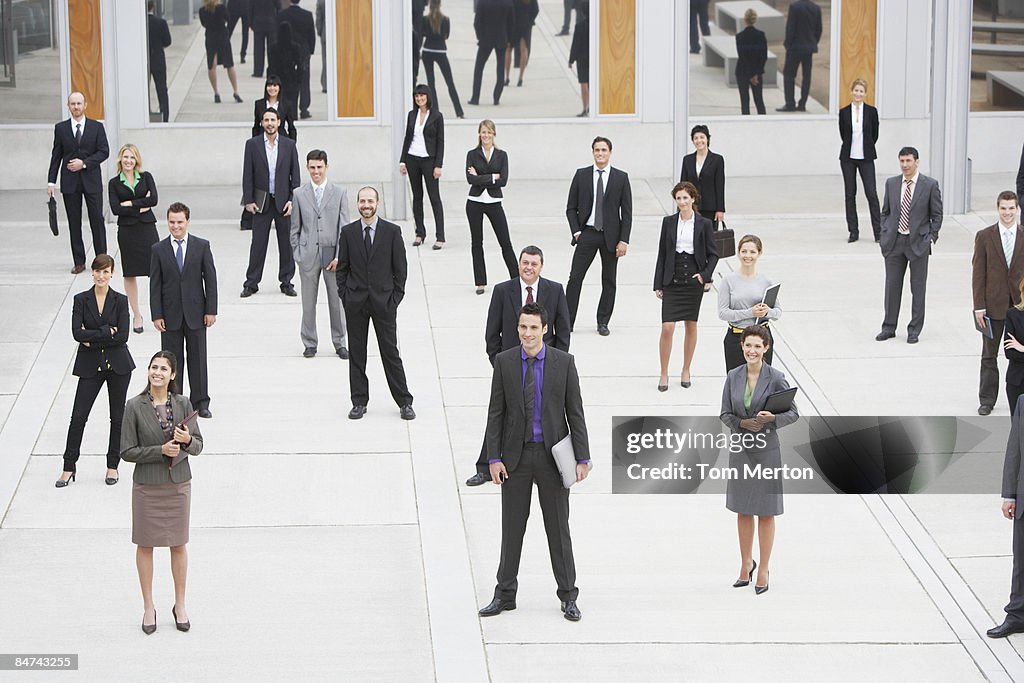 Businesspeople standing in office building courtyard