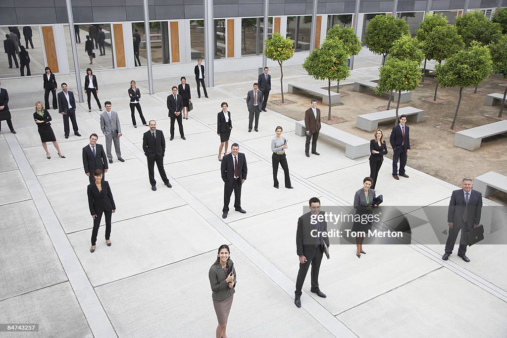 Businesspeople standing in office building courtyard