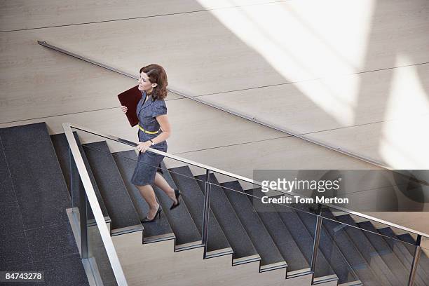 geschäftsfrau aufsteigender büro-treppe - hinauf bewegen stock-fotos und bilder