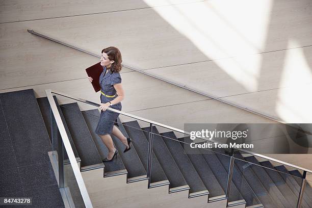 empresaria ascendente escalera de oficina - barandilla fotografías e imágenes de stock