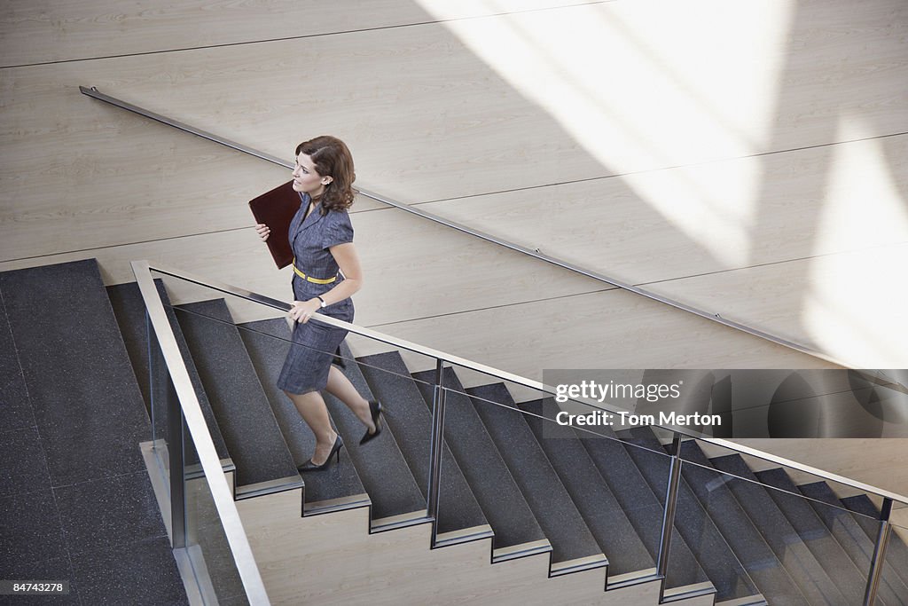 Businesswoman ascending office staircase