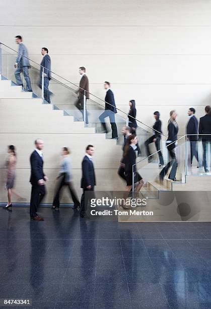 businesspeople walking on busy office staircase - bustling office stockfoto's en -beelden