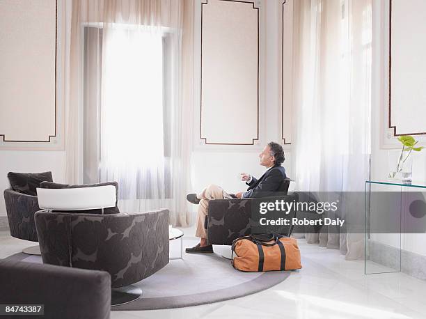man enjoying espresso in modern hotel suite - businessman hotel stock pictures, royalty-free photos & images