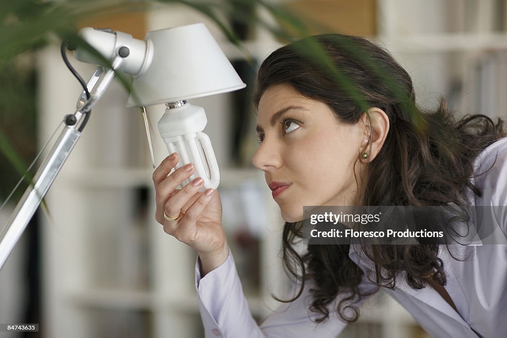 Woman changing lightbulb