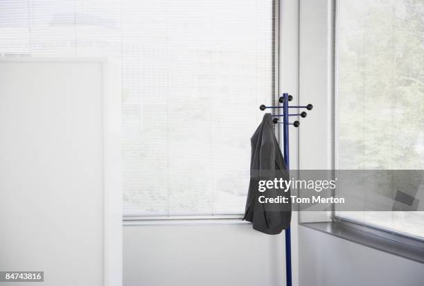 suit jacket hanging on office coat rack - suit rack stock pictures, royalty-free photos & images