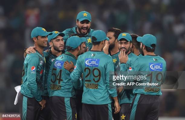 Pakistani cricketers celebrate after dismissal of World XI batsman Hashim Amla during the third and final Twenty20 International match between the...