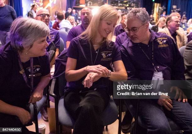 Cassini team member Nora Alonge, center, checks her watch with team members Scott Eddington, right, and Jo Pitesky, left, as clock ticks down to...