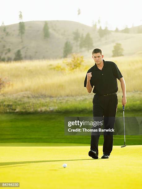 male golfer sinking put - golf excitement stock pictures, royalty-free photos & images